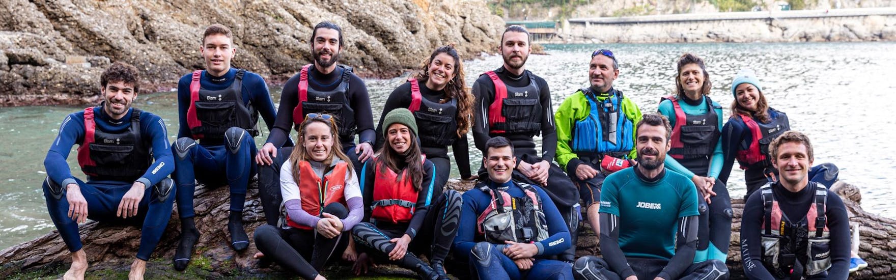 Gli istruttori di Outdoor Portofino sorridono seduti su una roccia.
