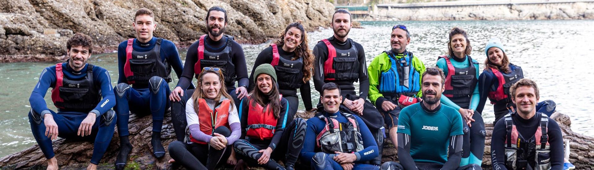 The instructors of Outdoor Portofino smiling while sitting together on a rock.