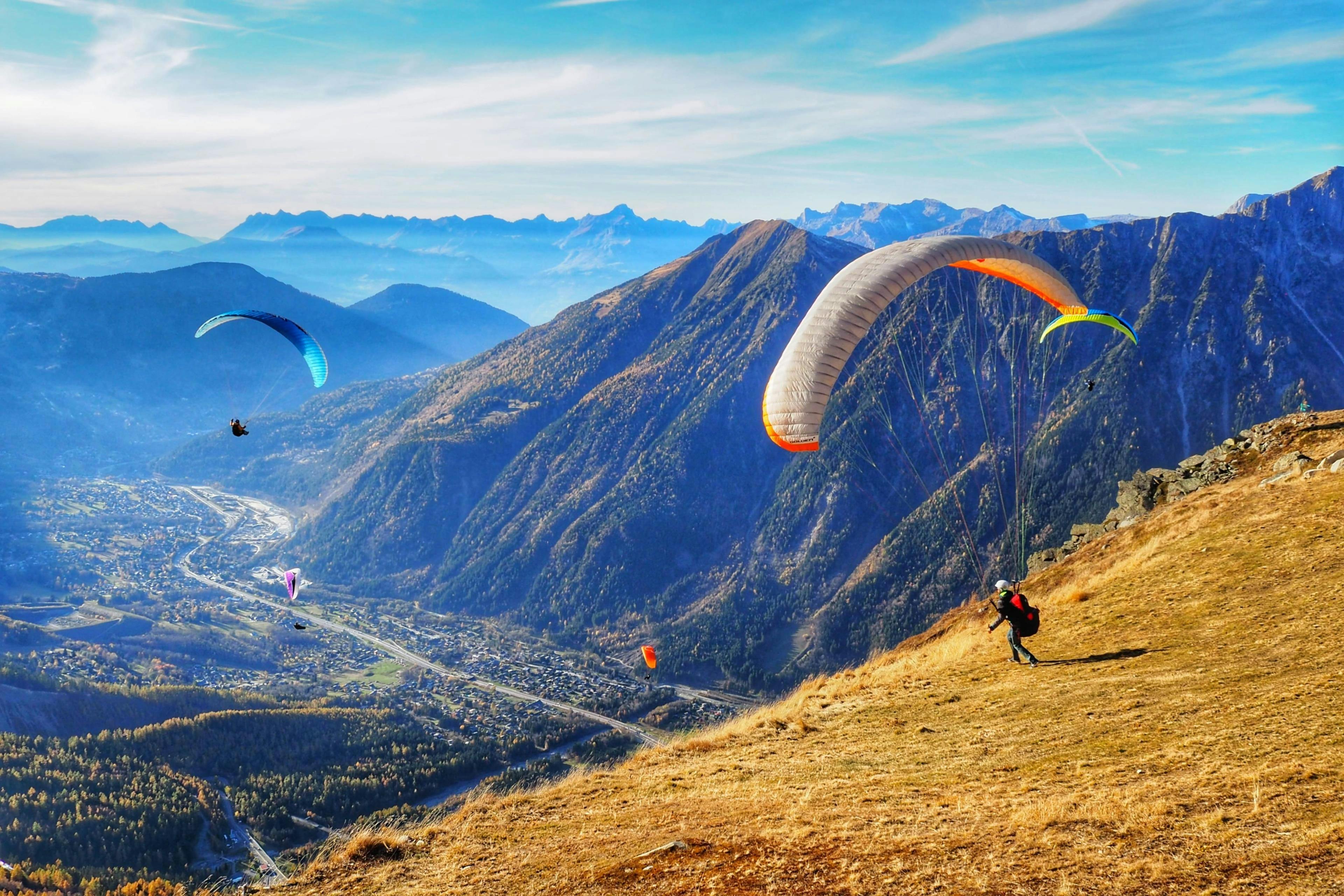 paragliding-chamonix_SEM-Resort-Hero A person is doing a paragliding flight in the Chamonix valley with the snowy mountains in the background.
