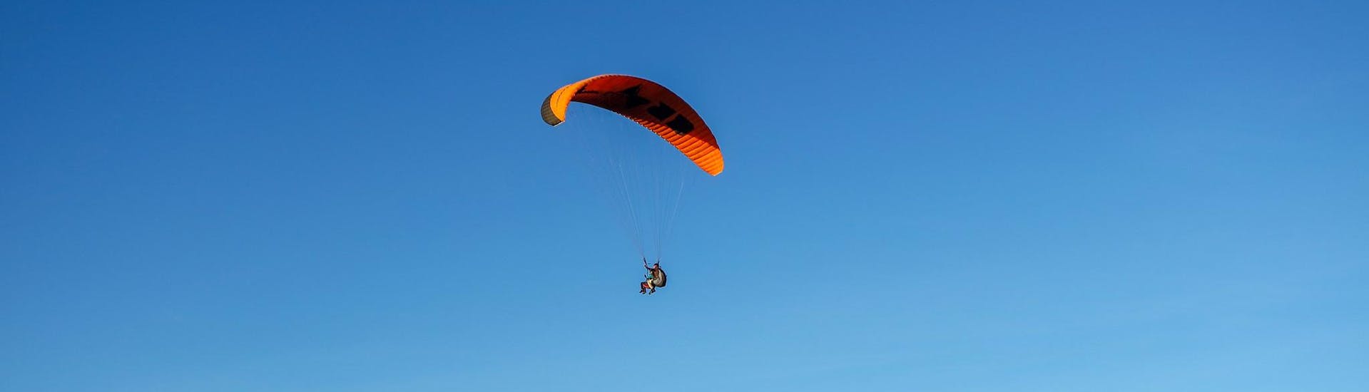Een instructeur en een kind tijdens een paragliding vlucht voor kinderen.