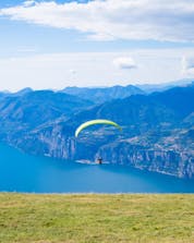 Ein einzelner Paraglider schwebt beim Paragliding am Gardasee über die malerische Landschaft.