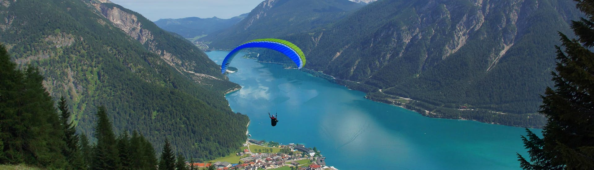 Un parapentiste est émerveillé par le paysage lors d'un vol en parapente biplace dans la célèbre destination de parapente Maurach.