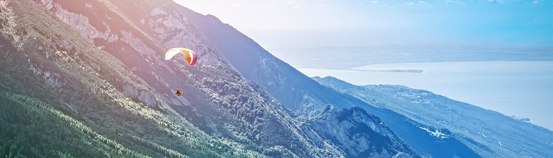 Una foto di un parapendio che vola dal Monte Baldo verso il Lago di Garda.