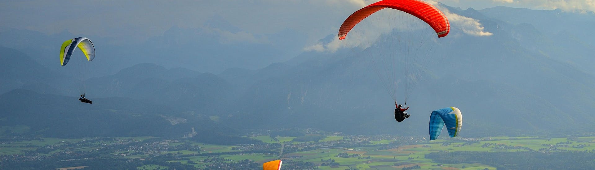 Un parapentiste est émerveillé par le paysage lors d'un vol en parapente biplace dans la célèbre destination de parapente Ville de Salzbourg.