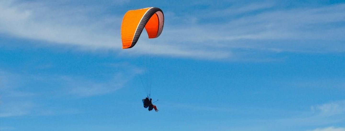 Two persons are paragliding in the Aran Valley with Parapente Pirineos at a high altitude.