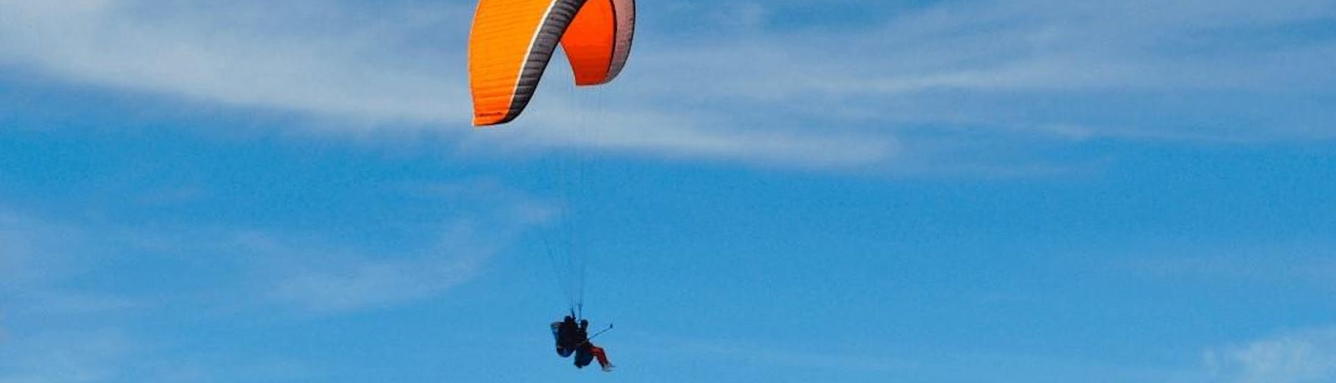 Two persons are paragliding in the Aran Valley with Parapente Pirineos at a high altitude.