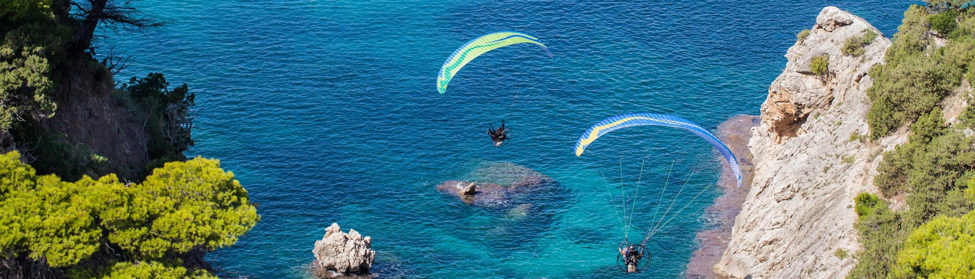 Un entusiasmado participante en un vuelo en parapente biplaza sobrevuela Varipetro, uno de los sitios más populares para volar en parapente.