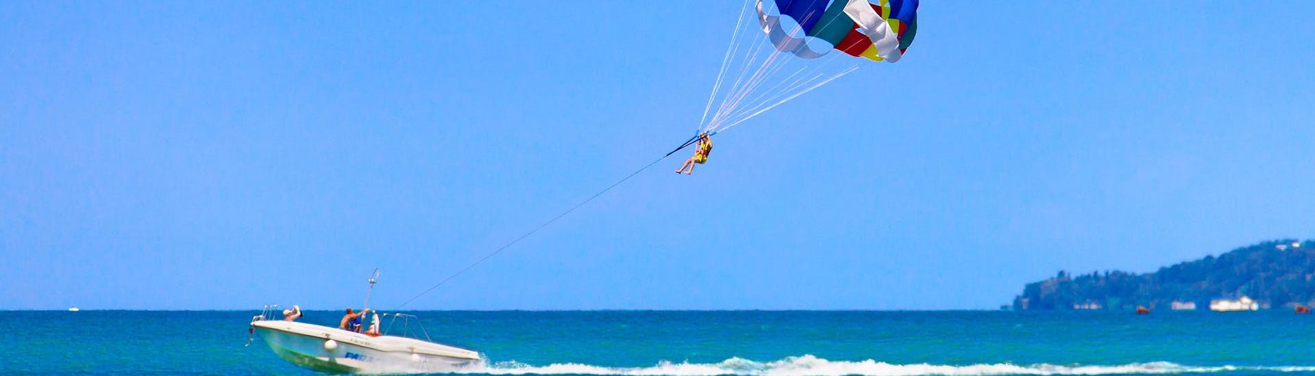 Una persona che si diverte durante un'attività di parasailing.
