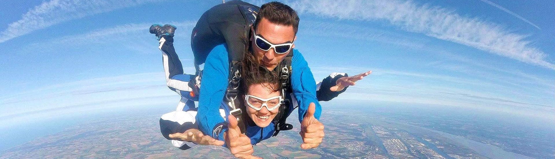 A woman is experiencing freefall with her Paris-Blois Parachutisme tandem skydiving instructor during her Tandem Skydive in Blois.