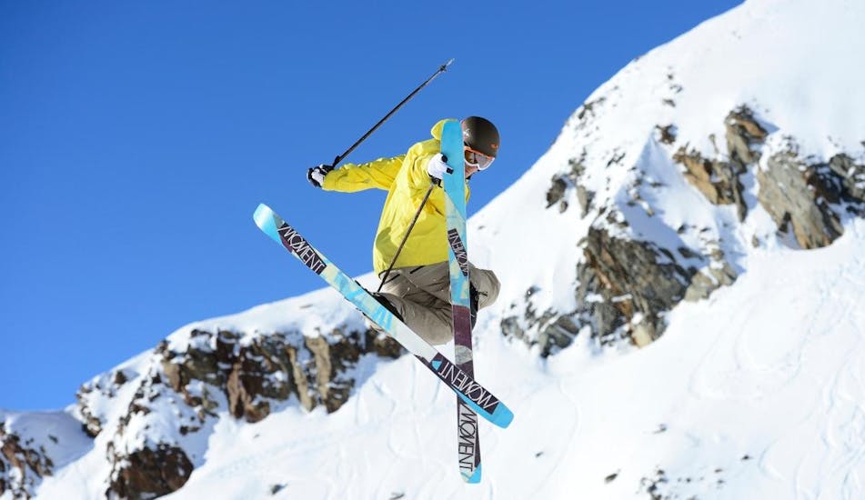 A freestyle skier is doing some tricks in the air as part of his Private Freestyle Skiing Lessons for All Levels with Escuela Española de Esquí y Snowboard de Cerler.