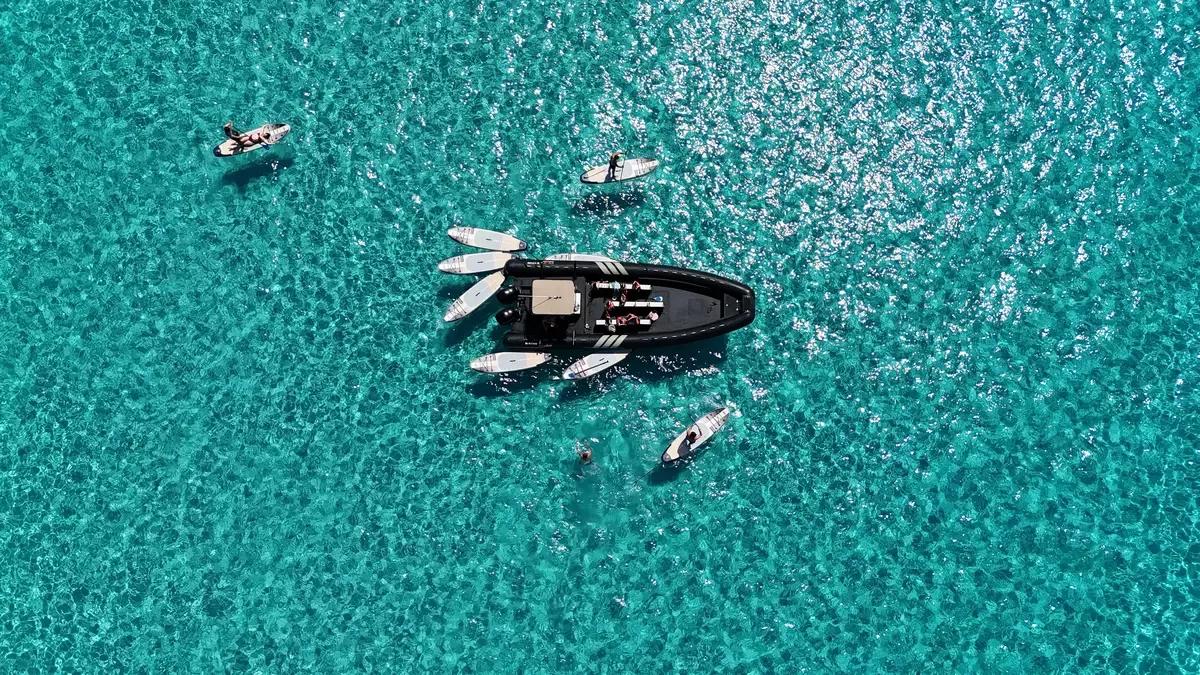 Il gommone di Perla Nera Saint-Florent con tavole da paddle su un’acqua turchese.