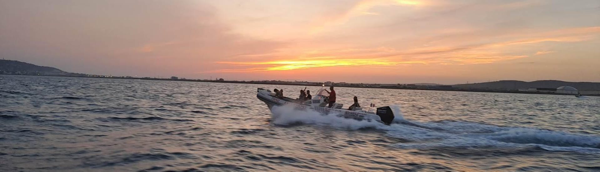 Thau Excursions' RIB boat on the sea at sunset.