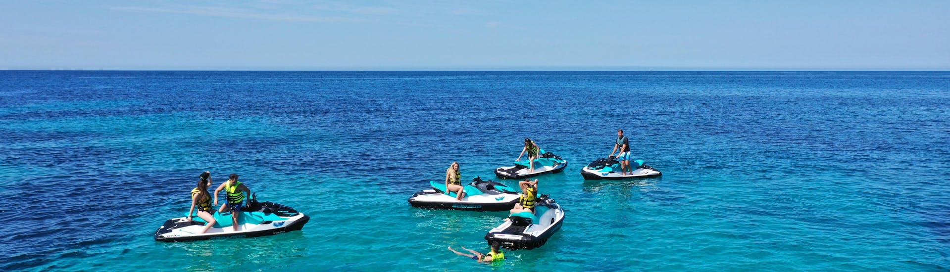 People enjoying aboard of the jetski in the middle of the sea.