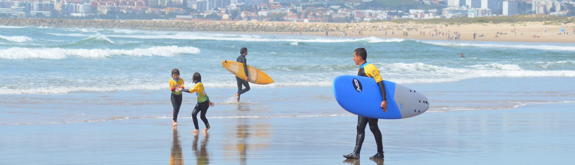 Persoon die surfplank draagt van Portugal Surf School.