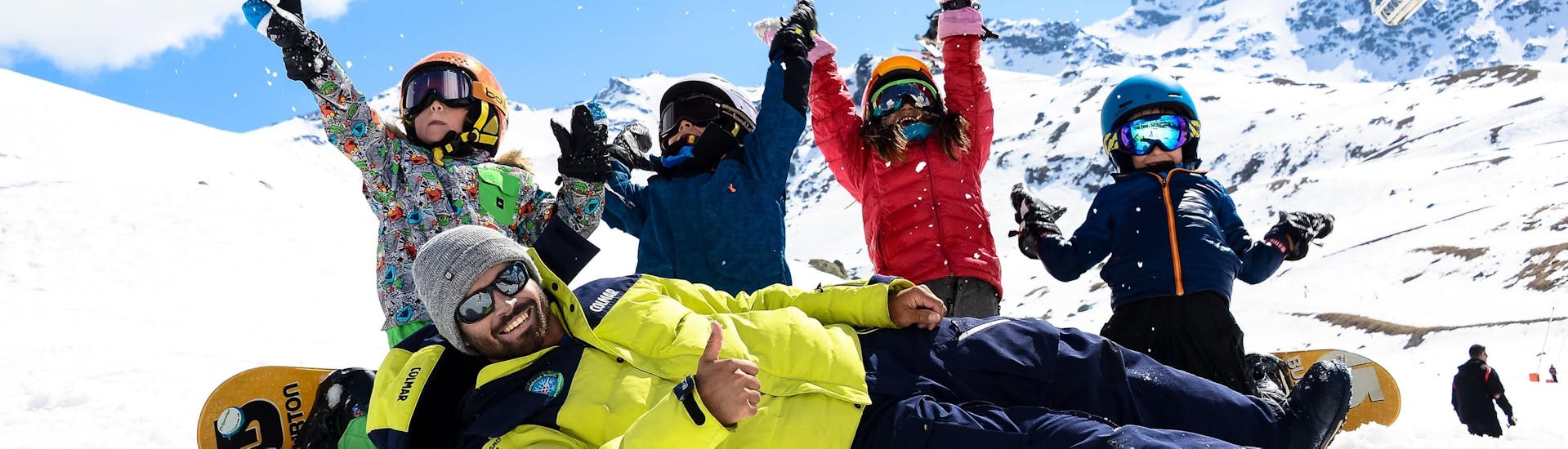 Des enfants heureux participents à un cours de snowboard avec l'école de ski Prosneige Val d'Isère situé dans la station de ski Val d'Isère.