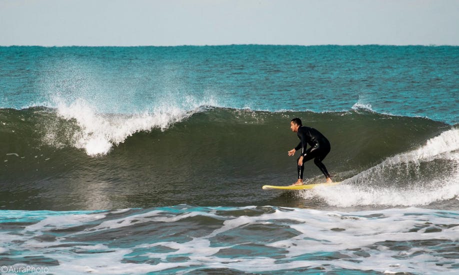 A man riding a wave and enjoying a surf lesson with Pura Vida Surfing School.