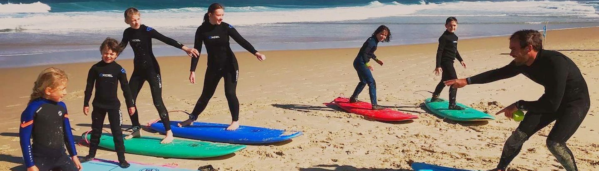 Un groupe apprend à surfer sur la plage de la Salie pendant les cours de surf pour tous les niveaux avec le moniteur de l'école de surf Pyla.