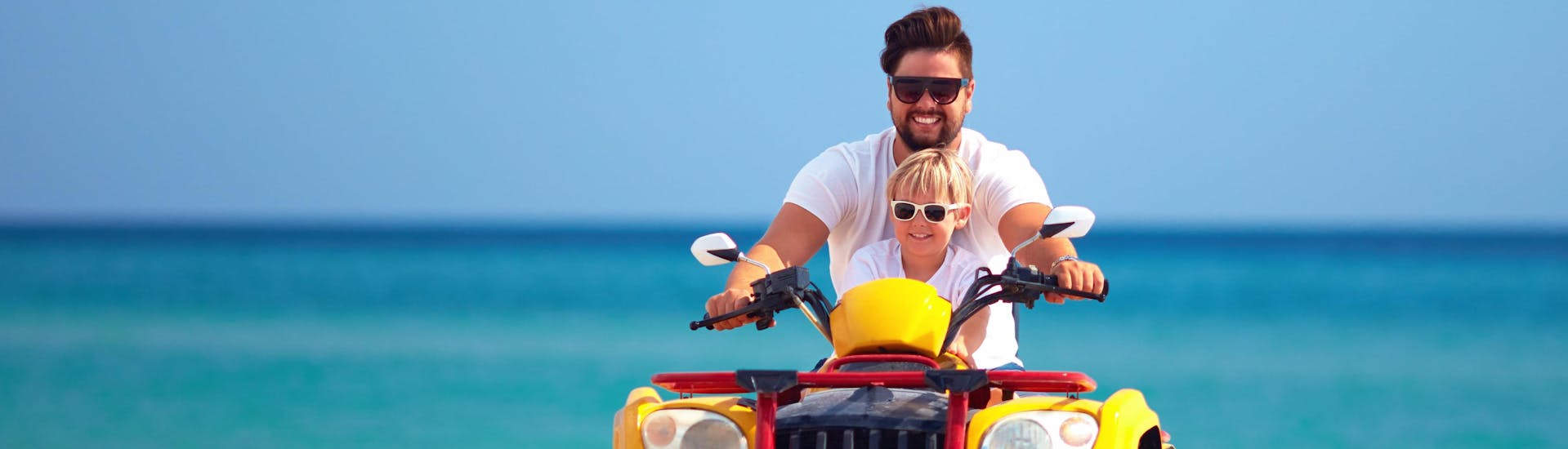 A young dad quad biking with his son in the holiday destination of Santorini.