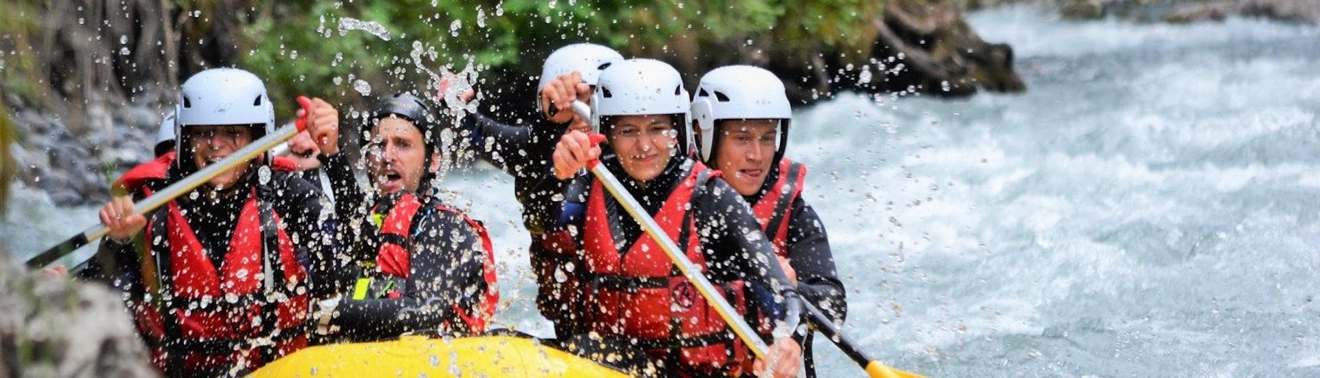 A group of friends is paddling in the rapids of the Giffre River where Raft Rider offers rafting tours in Haute-Savoie near Samoens.