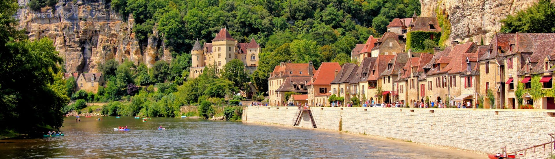 Beautiful view of the village of La Roque-Gageac on the Dordogne River on which tourists tourists do canoeing during summer.