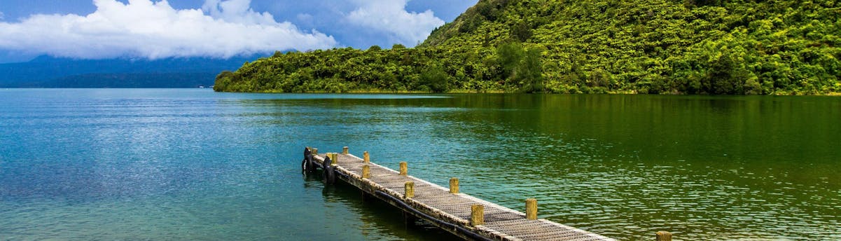 rafting-canyoning-lake-tarawera_SEM-Resort-Hero An image of a jetty leading into the clear waters of Lake Tarawera in the Rotorua region, a popular hotspot for kayaking in New Zealand.