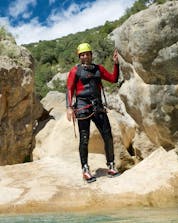 Un hombre de pie en una roca posa para una foro mientras desciende un barranco en Mallorca.