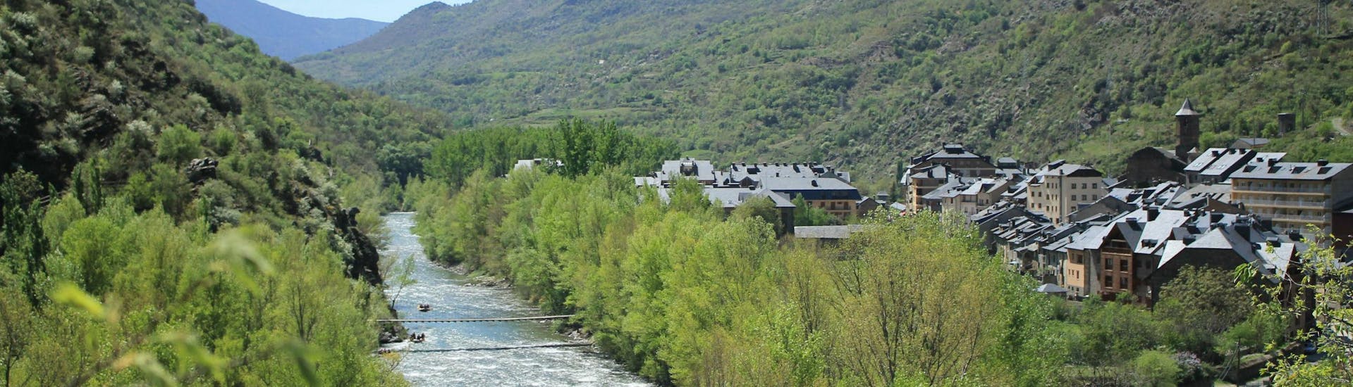 Varios grupos de personas navegan sus lanchas en el Rio Noguera Pallaresa mientras hacen rafting en Pallars Sobirà.