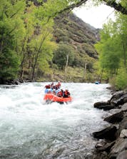Two groups of people are paddling downstream while rafting in Llavorsí.