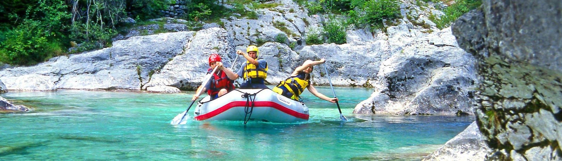 A group of friends having fun on a white water rafting tour in the rafting hotspot of Soča Valley .