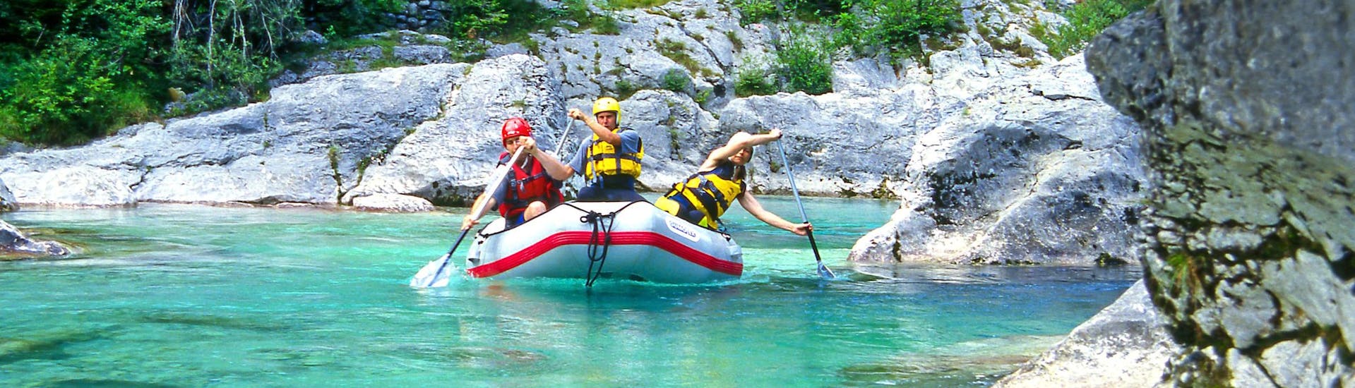 A group of friends having fun on a white water rafting tour in the rafting hotspot of Soča.