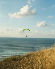 A photo from a man above a beach in the beautiful place of sopelana while paragliding.