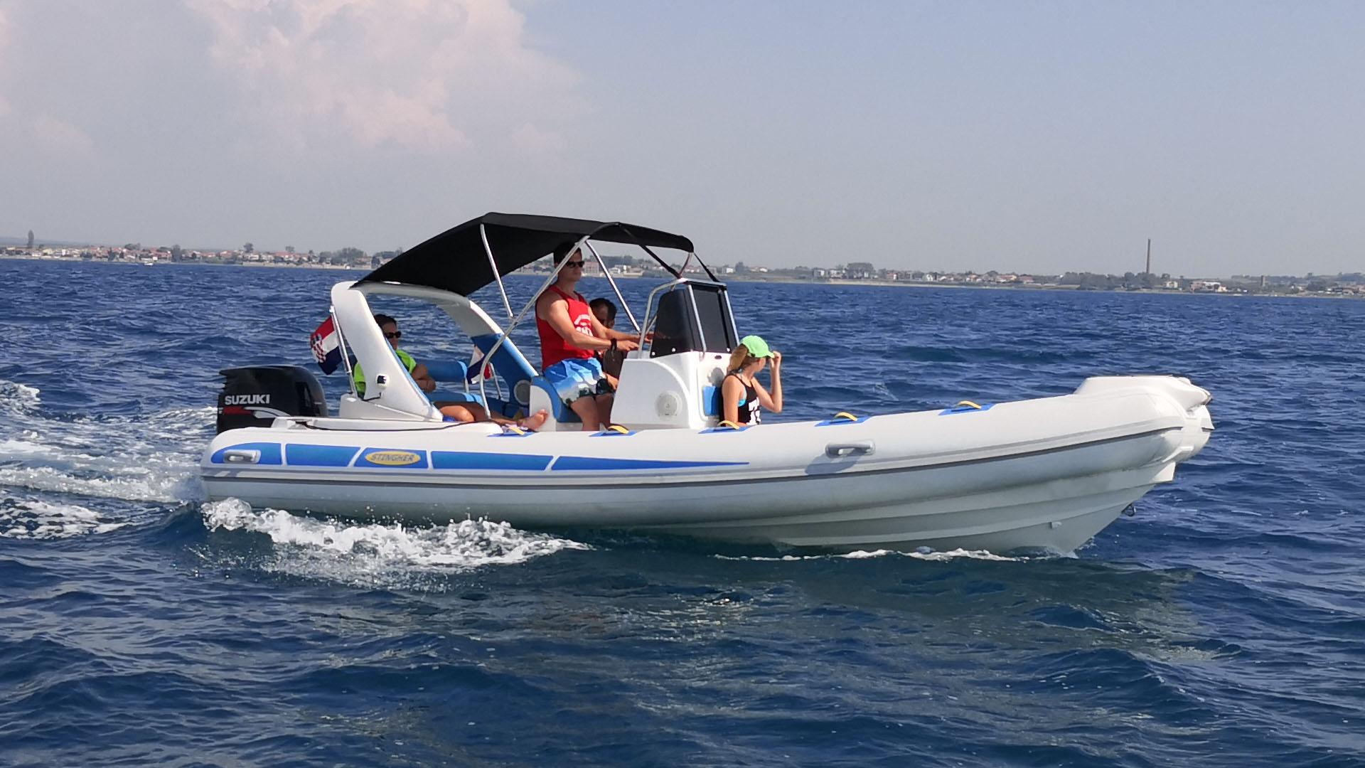 Una famiglia si gode il panorama insieme durante il noleggio di una barca organizzato da Rent a boat Nin Oaza-ML.