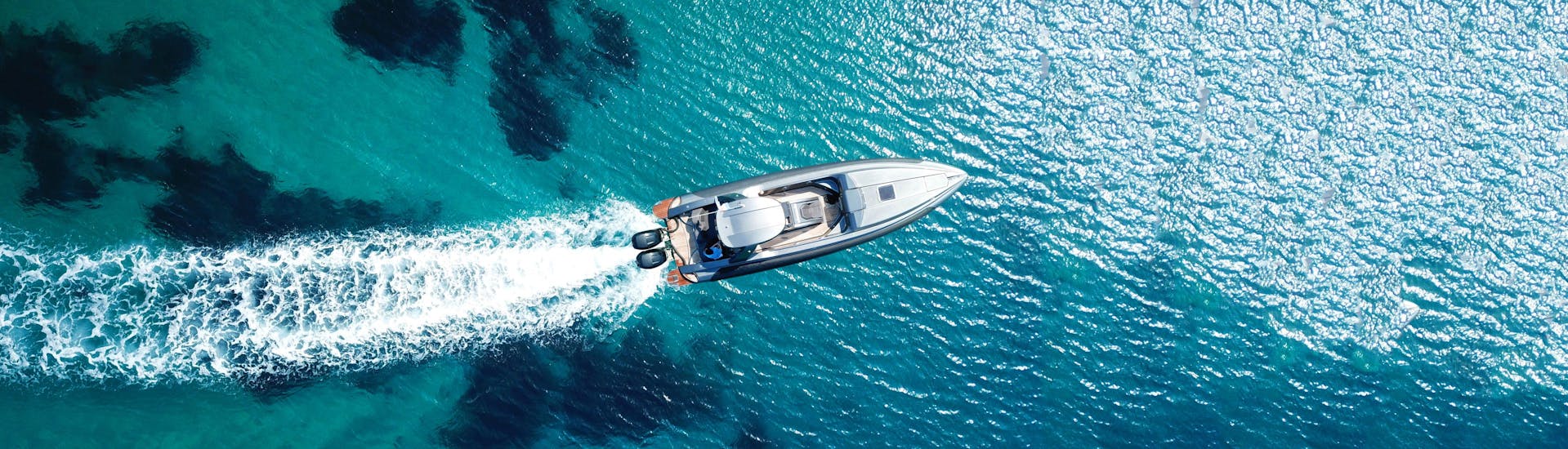 People enjoy a RIB Boat bouncing over the sea in transparent water after taking advantage of a RIB boat rental