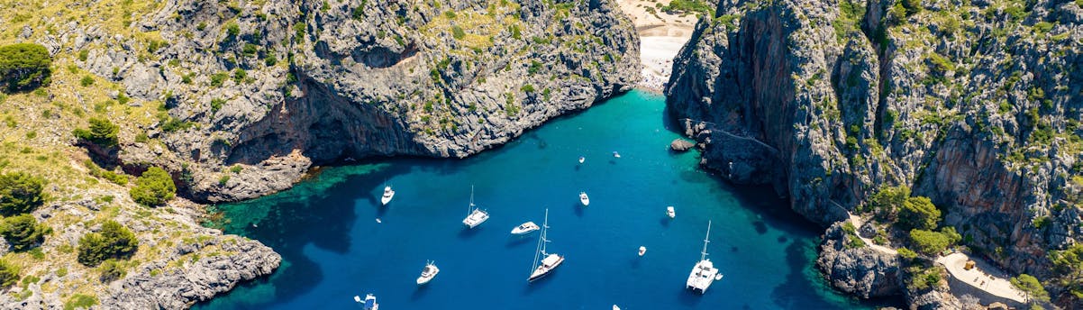 Tour in barca Sa Calobra Vista panoramica sulla costa di Sa Calobra con acque turchesi e scogliere rocciose.