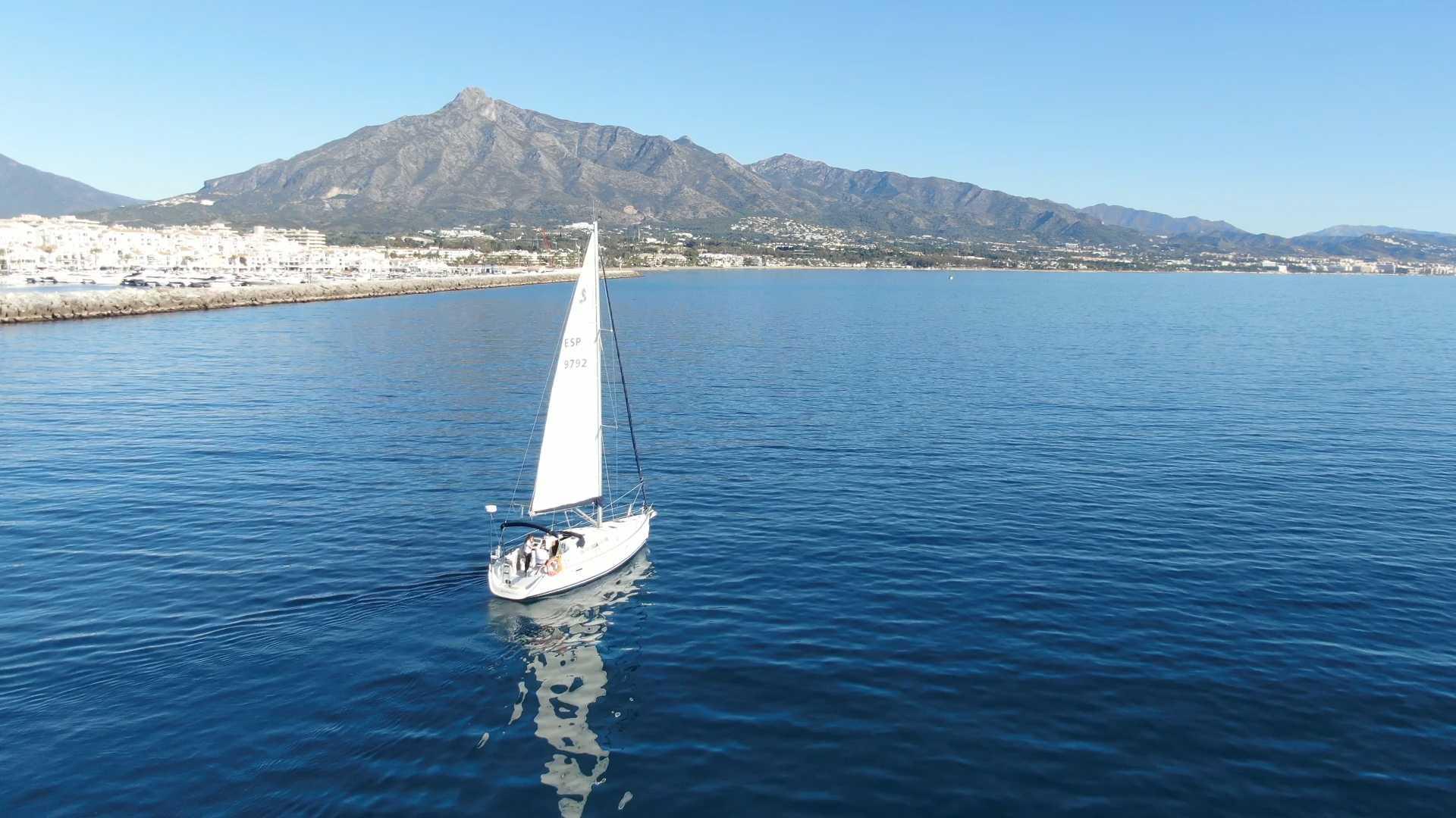 Ein Segelboot segelt im Mittelmeer mit atemberaubender Aussicht von Sail in Spain Marbella.