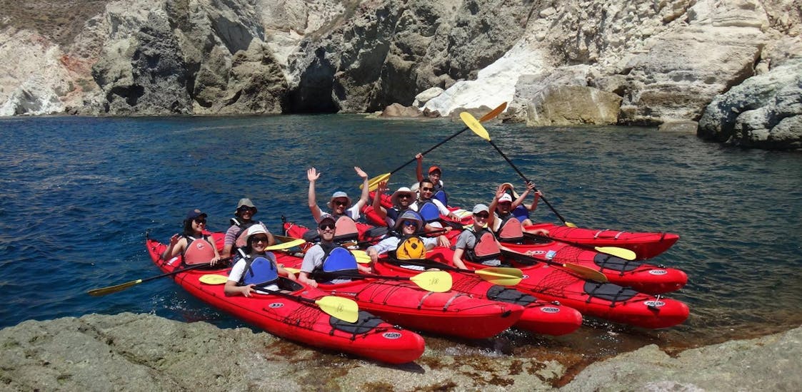A group of friends is making a stop during their sea kayak trip in Santorini which is led by professional kayak guides from Santorini Sea Kayak.