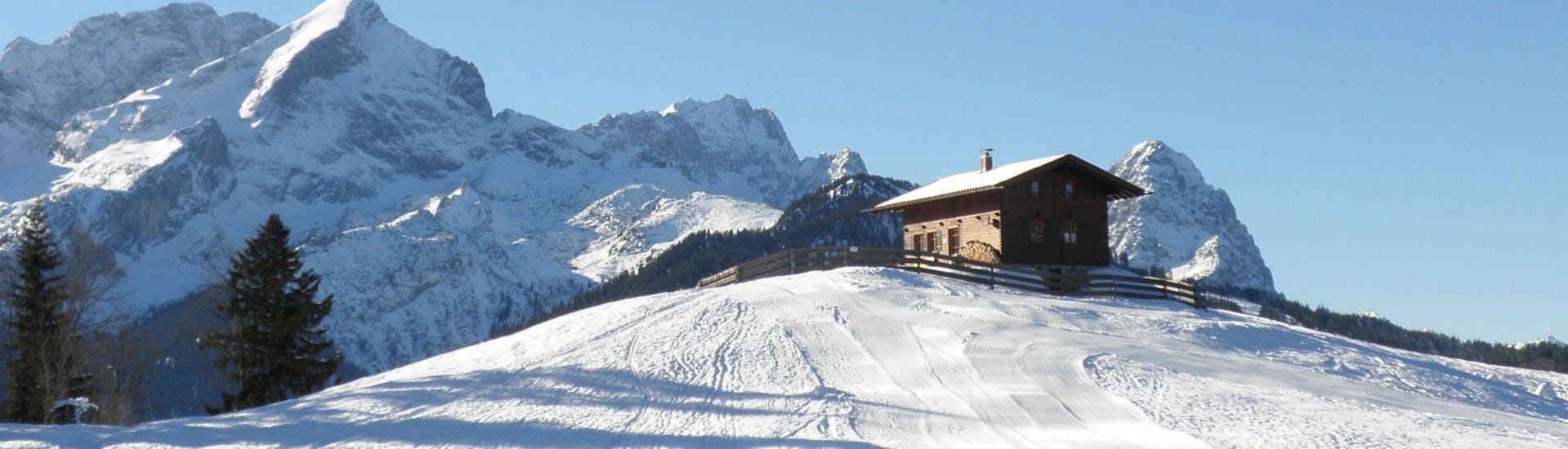 A small hut is perched on top of a ski slope in the Ski Resort of Garmisch-Classic, where the ski school Schneesportschule Morgenstern carries out its ski lessons.