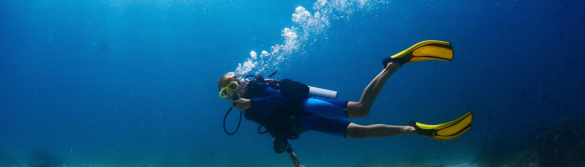 Een man kijkt naar de camera tijdens een duikactiviteit rond het eiland.