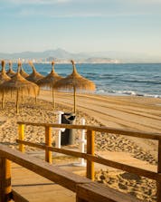 Una imagen de una pasarela de madera que lleva a una maravillosa playa de arena blanca que la gente podrá disfrutar cuando haga buceo en Santa Pola.