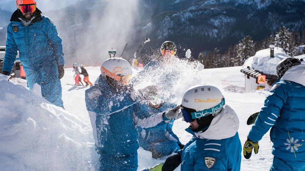 Die Skilehrer der Skischule Scuola di Sci e Snowboard Cristallo Cortina vergnügen sich im Schnee auf einer der Pisten im Skigebiet Cortina d'Ampezzo, wo sie ihre Skikurse anbieten.