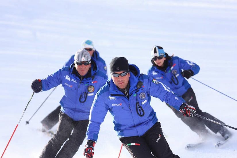 A group of ski instructors of the ski school Scuola di Sci Tre Nevi Ovindoli are mastering the slopes in the ski resort of Ovindoli on the Monte Magnola.
