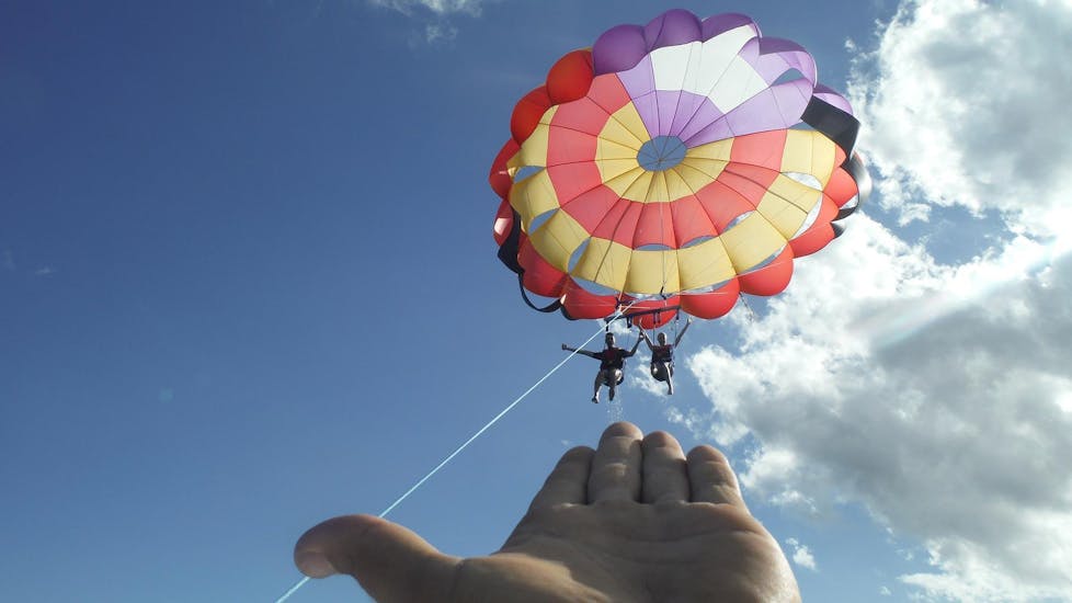Dos amigos disfrutan del vuelo de parasailing s a 100 metros de altura, organizado por Sea Sports Mallorca.