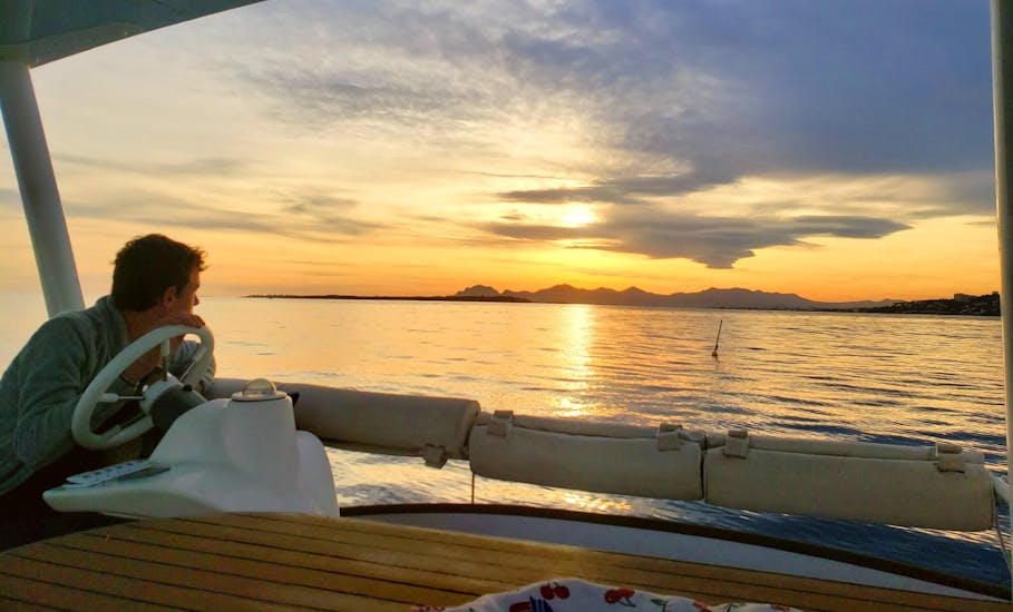 Un homme profite d'une balade privée en catamaran au coucher du soleil au large de Juan-les-Pins avec SeaZen.