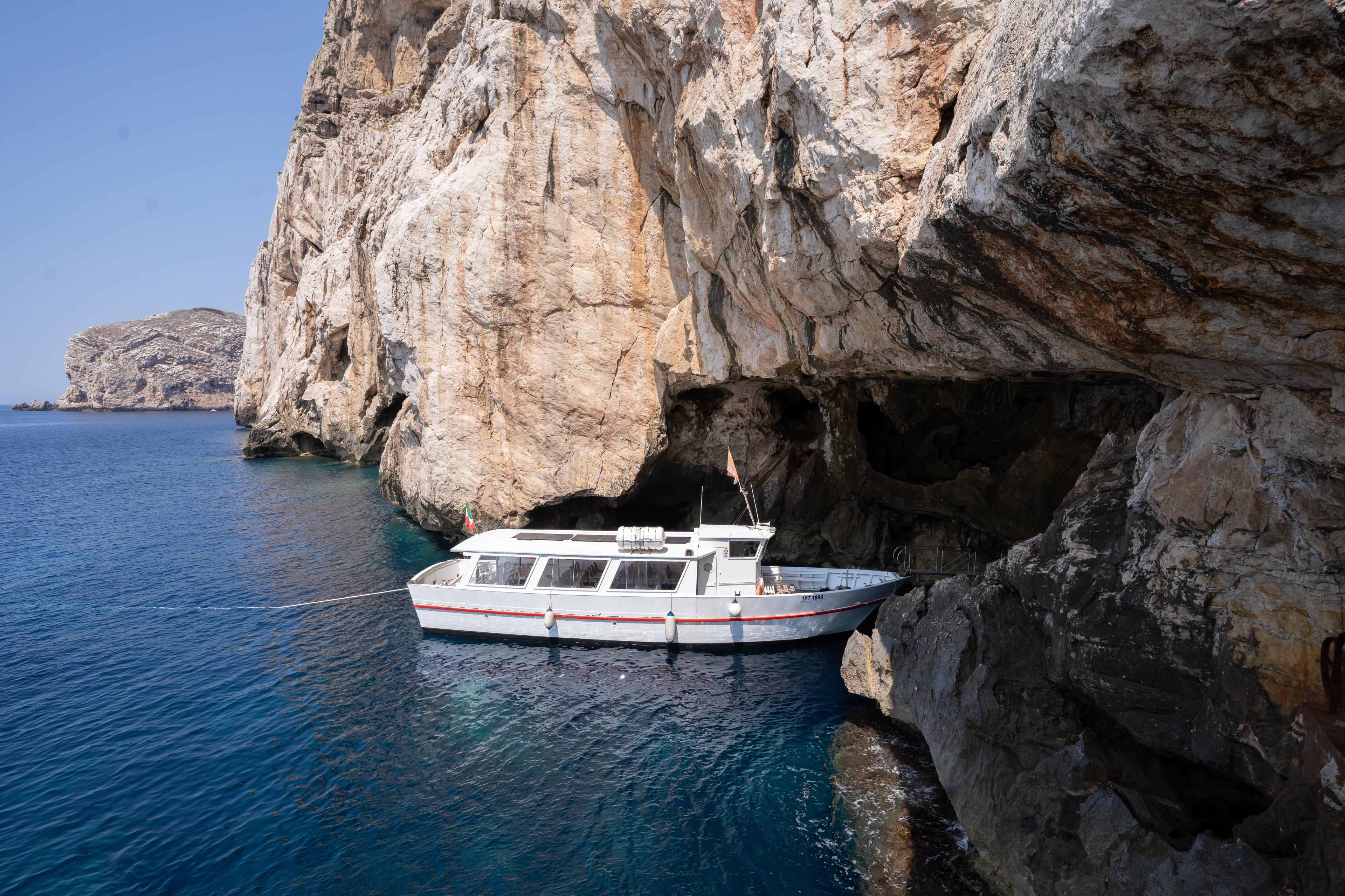Un bateau entre dans la grotte de Neptune, sur la côte de la Sardaigne, en Italie.