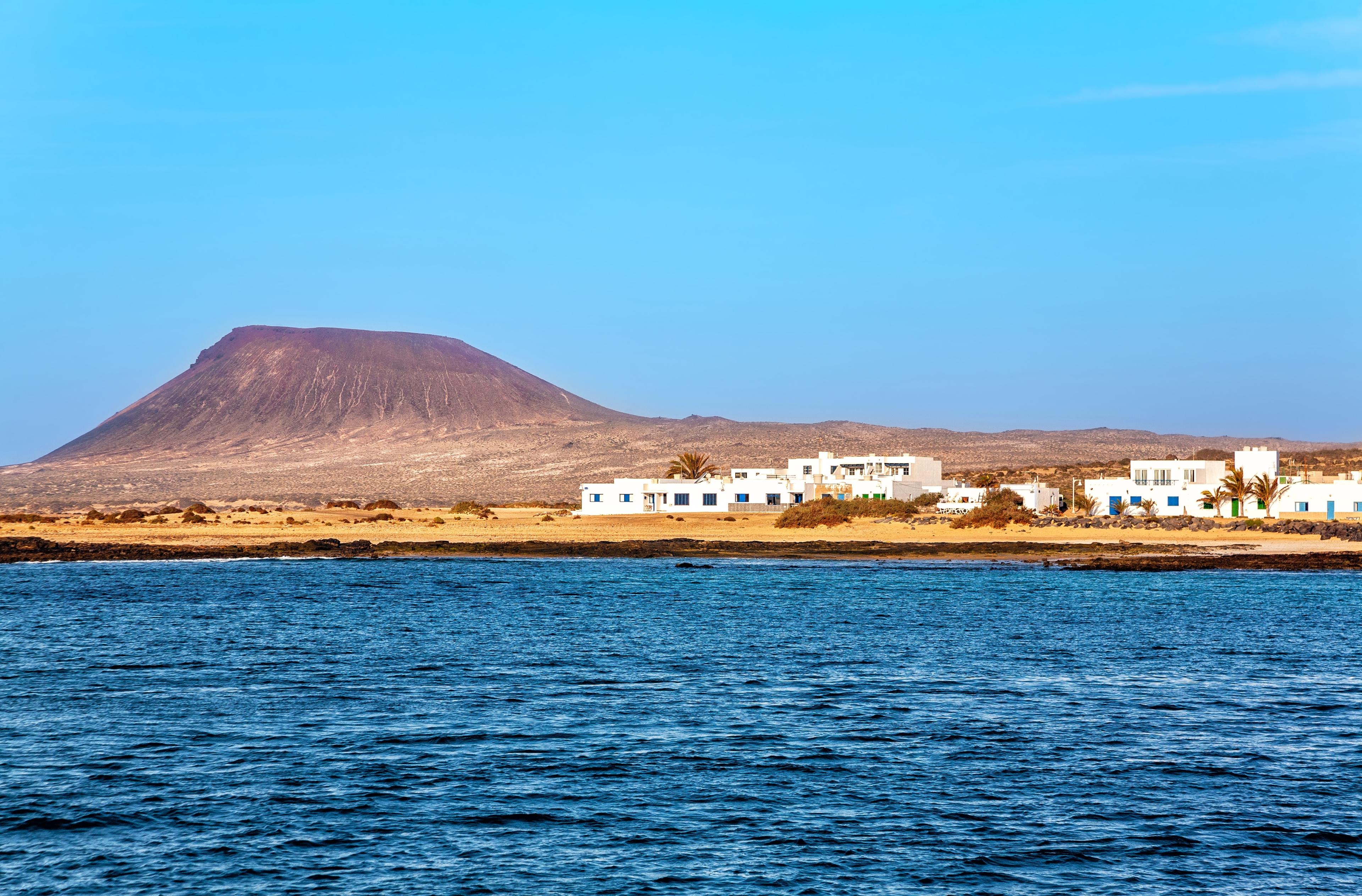 Vista de la isla de La Graciosa con playas de arena y paisaje volcánico.