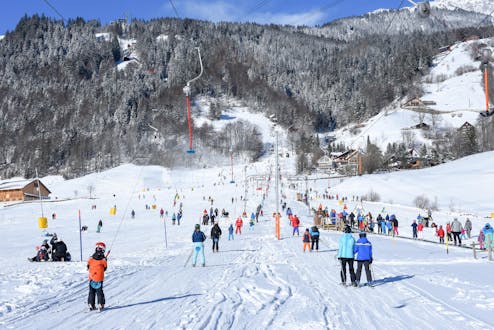 Adults and kids skiing in Engelberg ski resort.