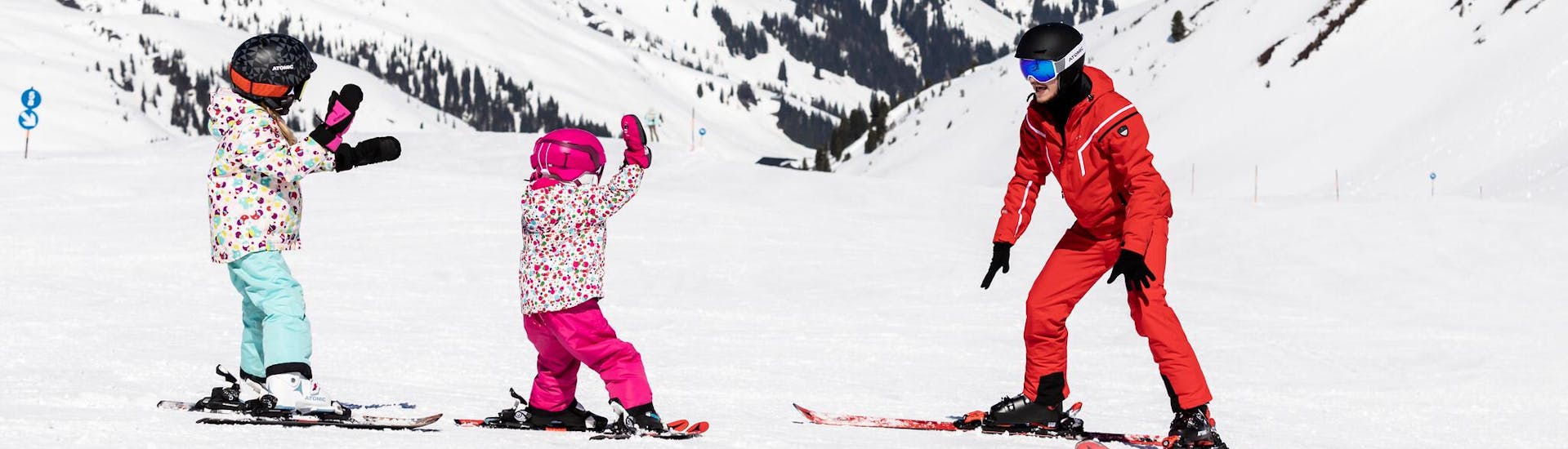 Due bambini sciano per la prima volta durante una lezione di sci per principianti