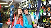 2 people renting skis in a local ski rental shop.