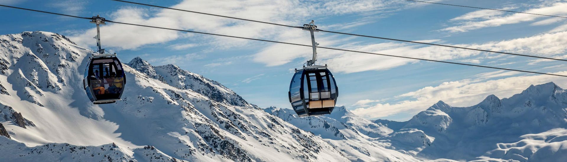 A view of the cable car carrying skiers up to the top of the mountain in the ski resort of Andermatt, where local ski schools offer a selection of ski lessons.