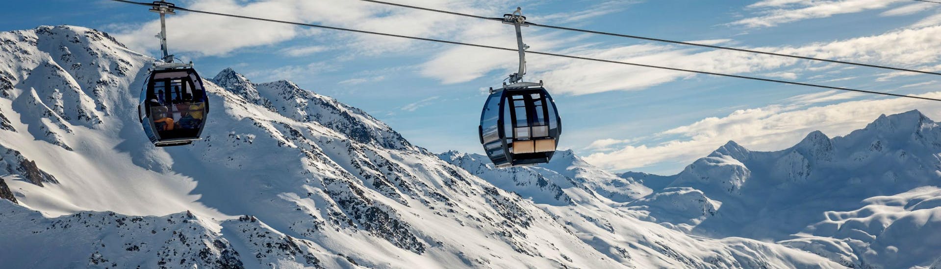 A view of the cable car carrying skiers up to the top of the mountain in the ski resort of Andermatt, not too far from Lucerne, where local ski schools offer a selection of ski lessons.